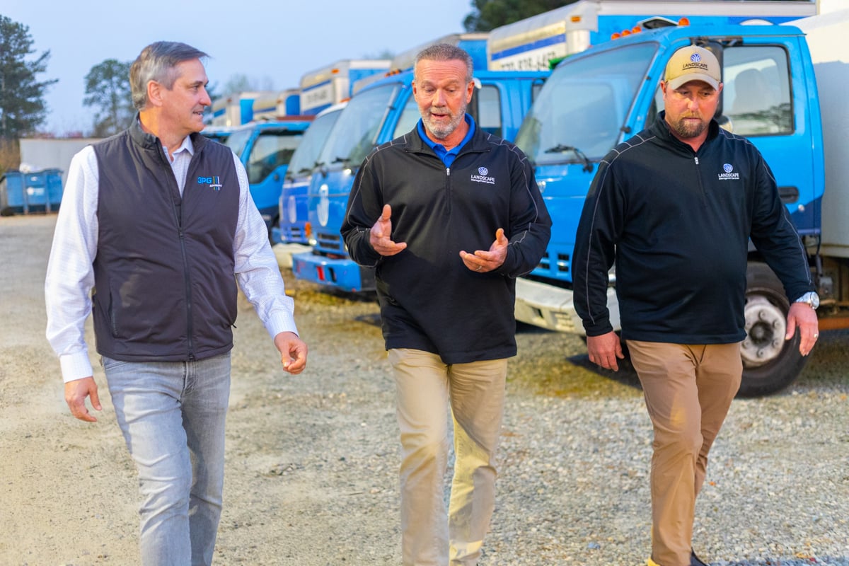 landscape management services company owner jeff harkness and manager walking through yard & shop during morning rollout